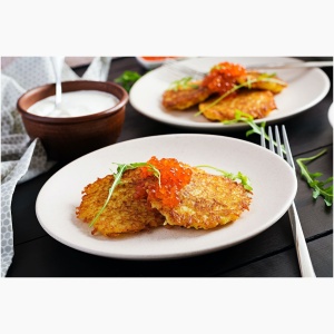 Fried potato pancakes with red caviar and sour cream, fritter, roesti